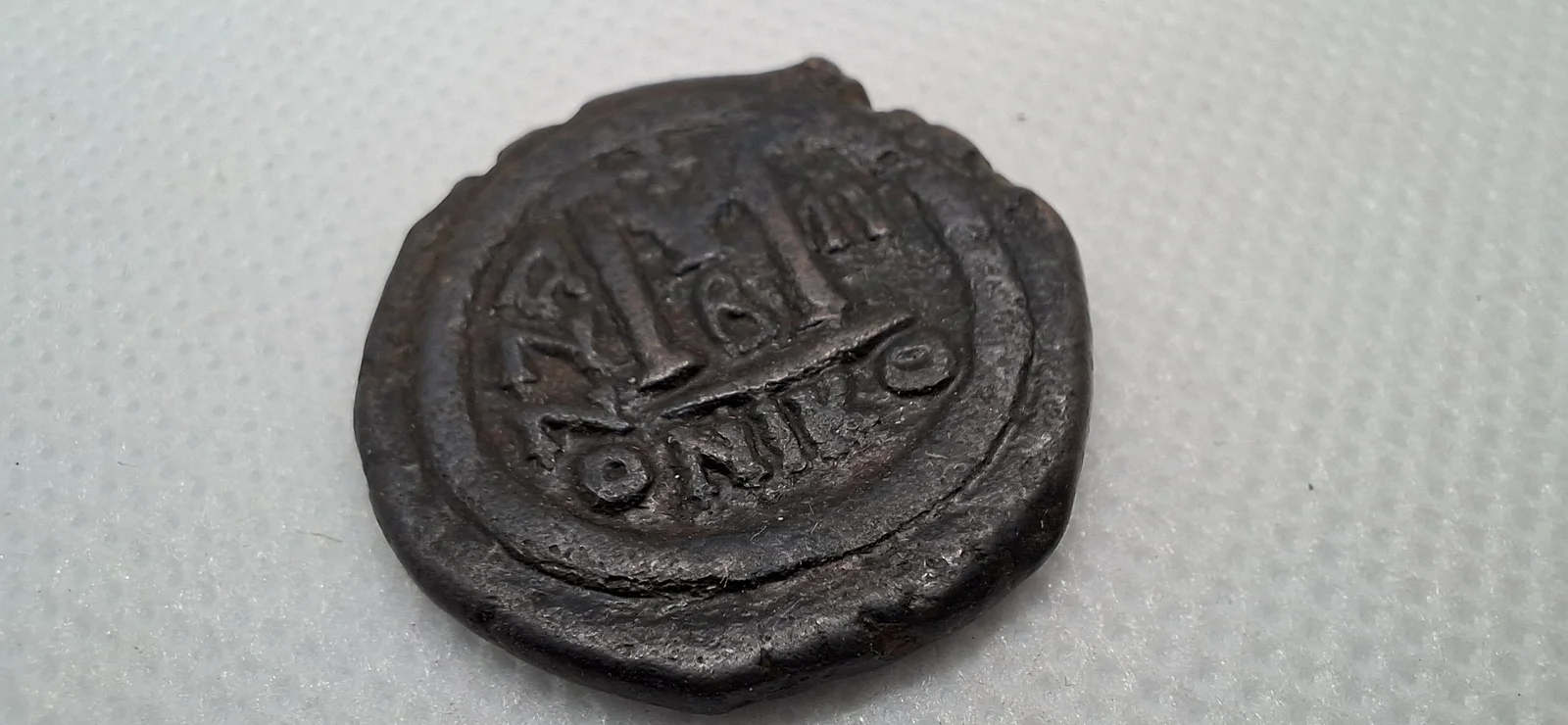 Reverso ampliado da moeda TH-N-0125 — Justino II e Sofia. Fólis de 40 nummi. Constantinopla, 566 a 567 d.C.