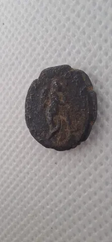 Lateral da moeda TH-N-0264 — Caracala. AE17 provincial. Thanatos com tocha invertida. Hadrianópolis, Trácia, 198–217 d.C.